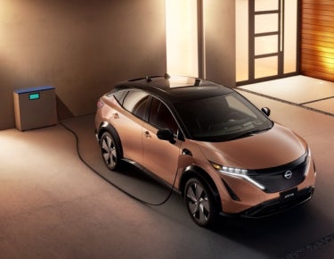 Nissan ARIYA plugged-in and charging outside a home | Nissan of Bowie in Bowie MD